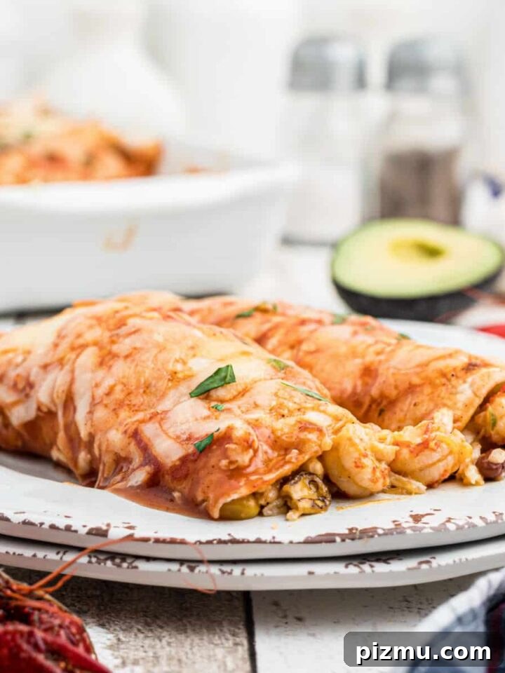 close up of a plate of crawfish enchiladas with some avocado in the background