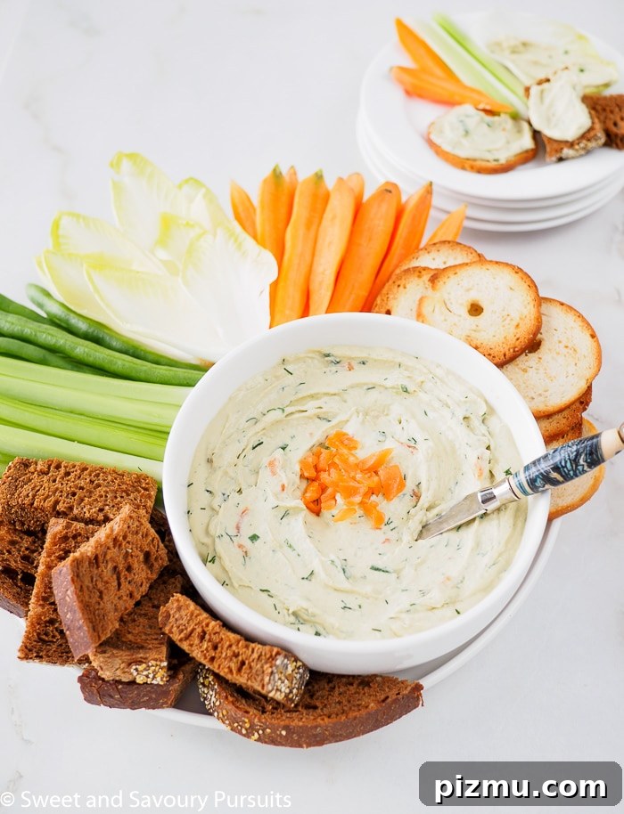 Smoked Salmon and Cream Cheese Dip Recipe 4 Close-up of a Smoked Salmon Dip served with fresh vegetables, bagel crisps and pumpernickel bread.