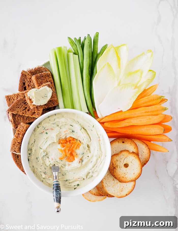 Smoked Salmon and Cream Cheese Dip Recipe 5 Top view of a bowl of Smoked Salmon and Cream Cheese Dip served with vegetables, pumpernickel bread and crackers.