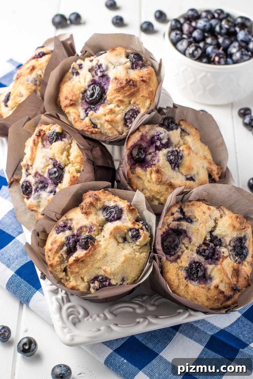 11 Keto Muffins for Quick Grab-and-Go Mornings 8 Keto blueberry muffins with a fluffy texture in brown muffin wrappers. The image is intended to show an example a low-carb and gluten-free breakfast idea perfect for busy mornings.
