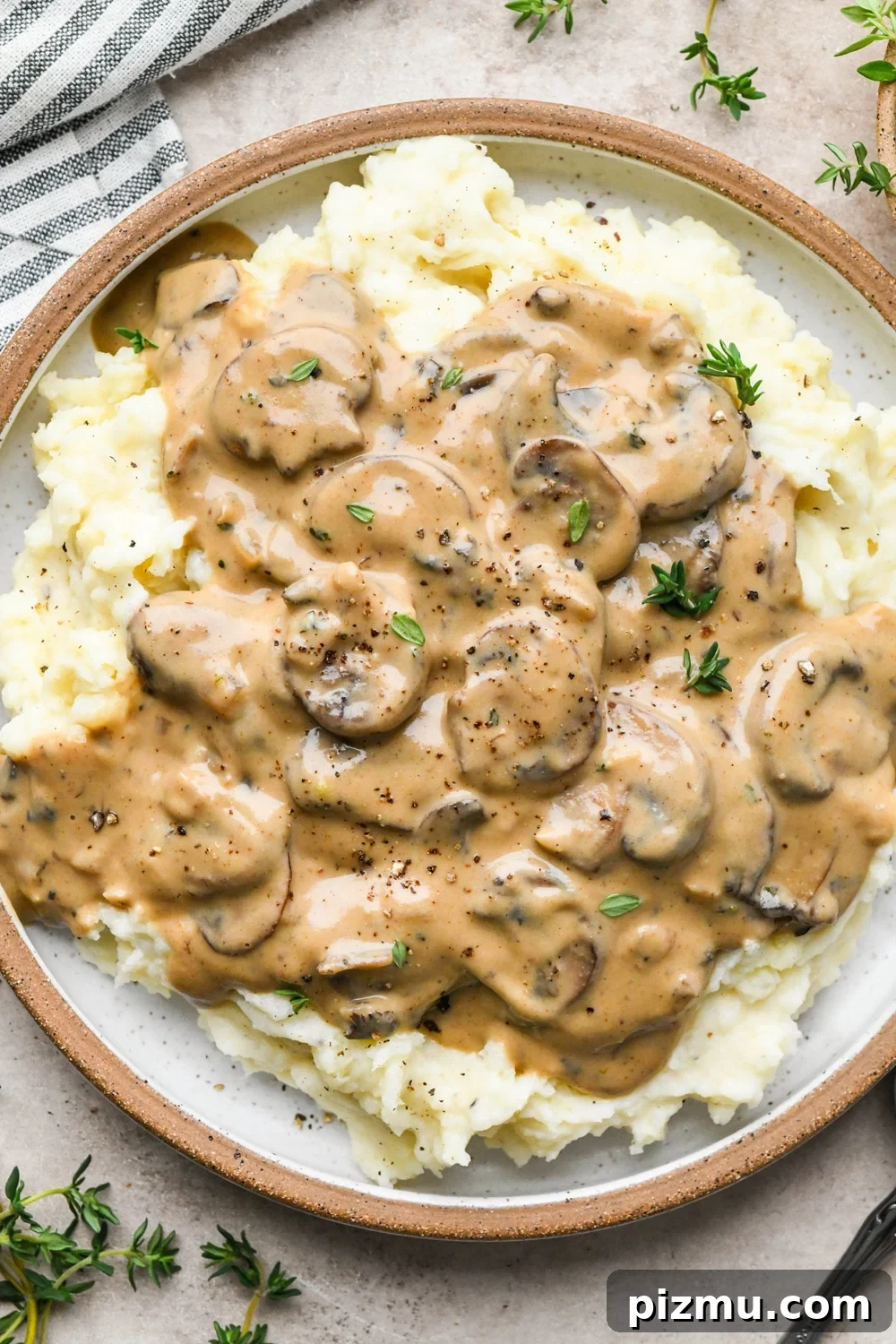 Creamy Gluten-Free Mushroom Gravy (Dairy-Free) 2 Creamy gluten free mushroom gravy over mashed potatoes on a ceramic plate.