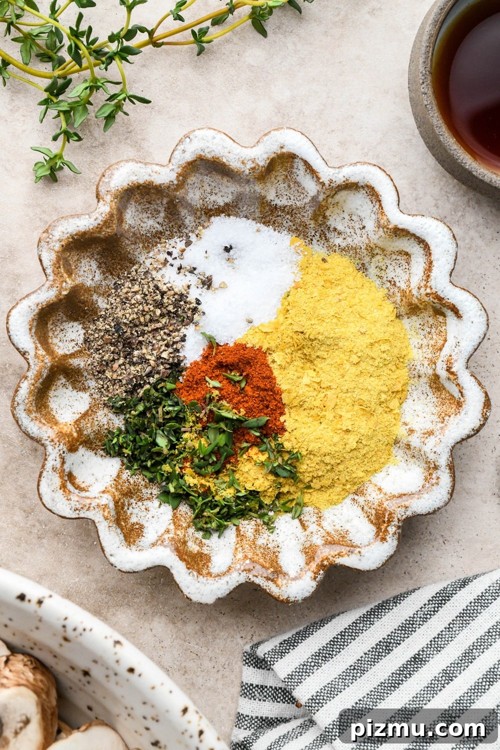 Creamy Gluten-Free Mushroom Gravy (Dairy-Free) 4 A small ruffled brown ceramic dish with spices and herbs for mushroom gravy.