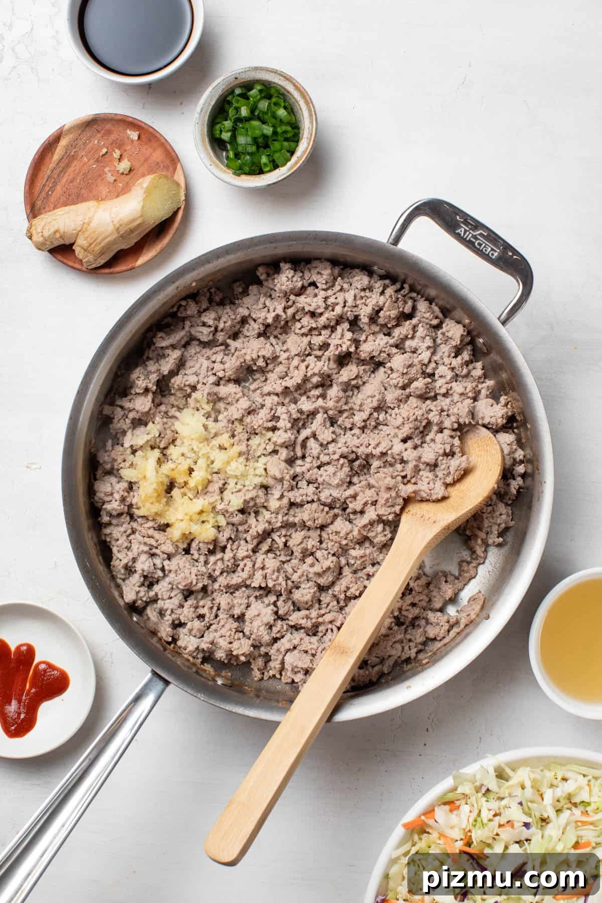 Ground Turkey Egg Roll Bowl with Soy-Ginger Sauce 5 Adding garlic and ginger to the ground turkey in a pan.
