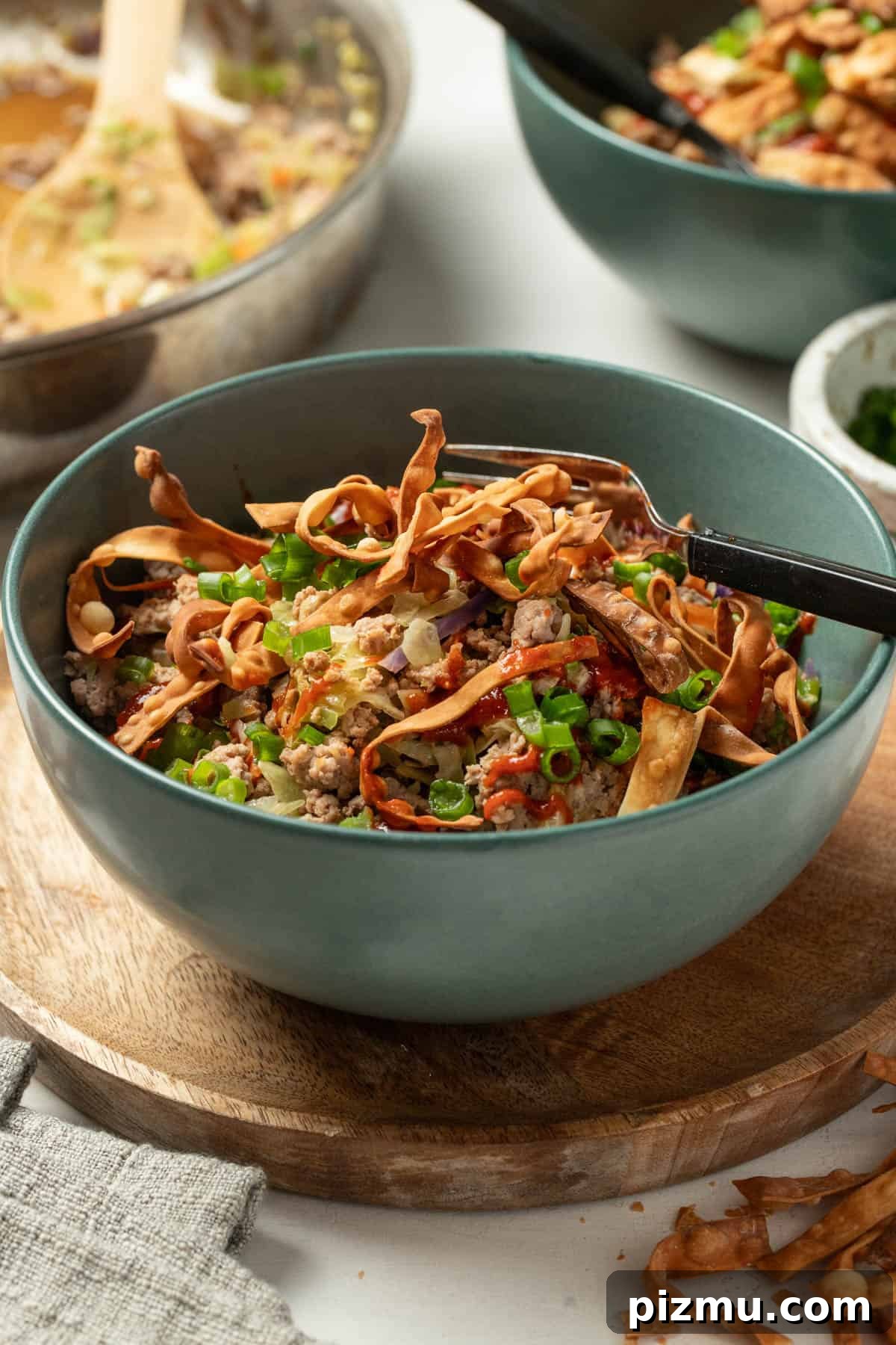 Ground Turkey Egg Roll Bowl with Soy-Ginger Sauce 10 Crispy egg roll wrappers on top of a stir fry bowl.