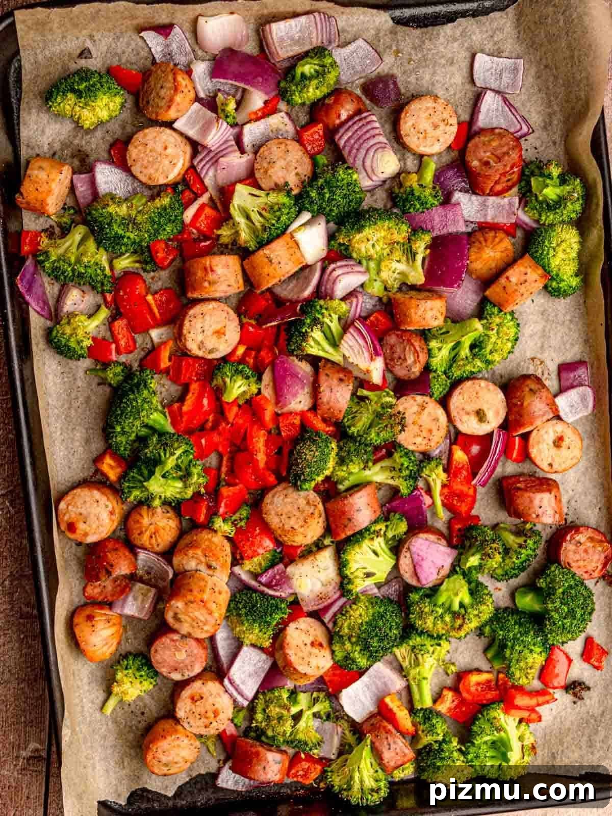 Sheet Pan Italian Sausage with Peppers and Broccoli Recipe 2 Cut sausage with pepper, broccoli and onion on a pan.