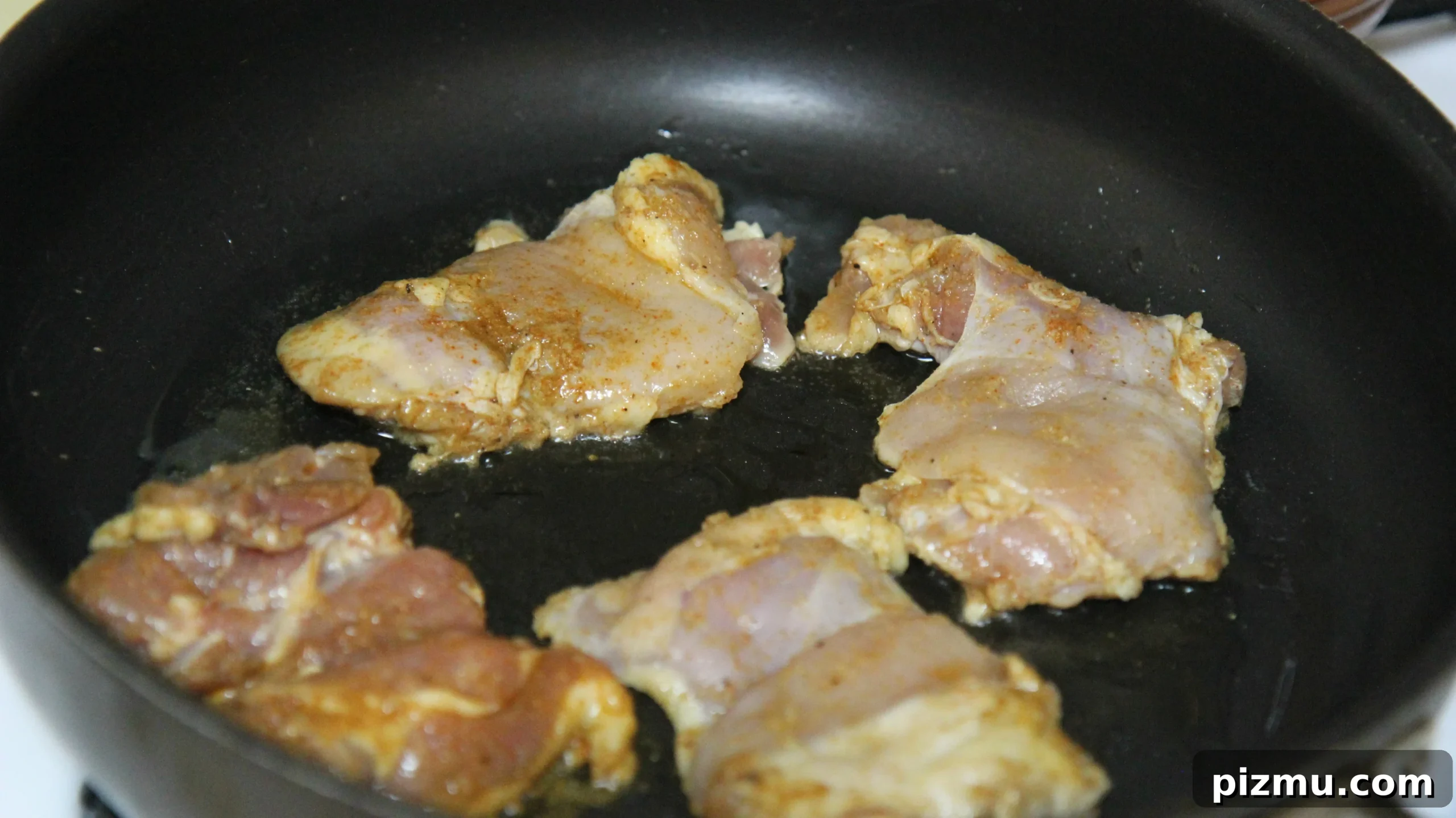Where to Find NYC Halal Cart Chicken and Rice 3 chicken thighs in a skillet.