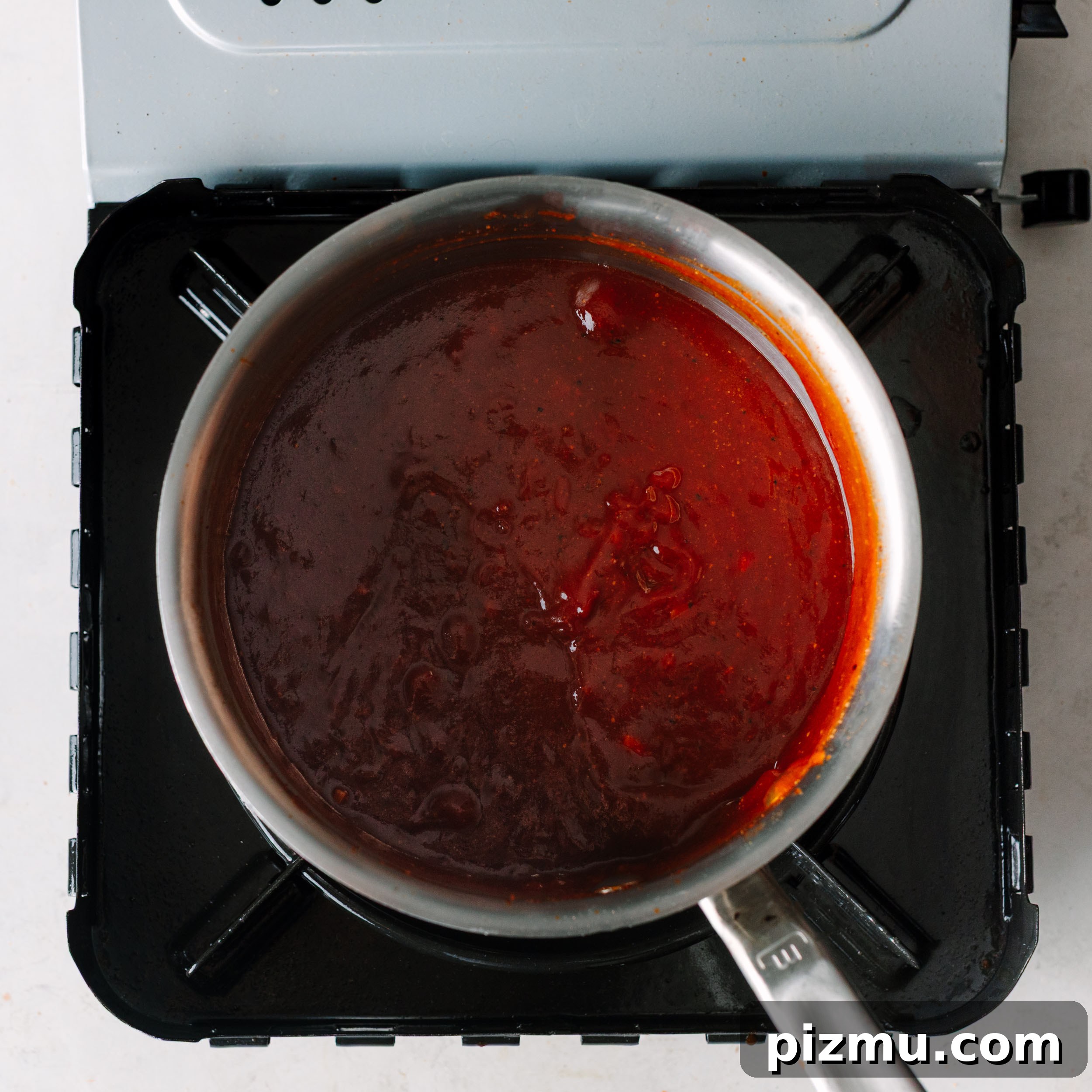 Buffaque Wings Recipe: Buffalo BBQ Chicken Wings 11 Simmering sauce in a saucepan.