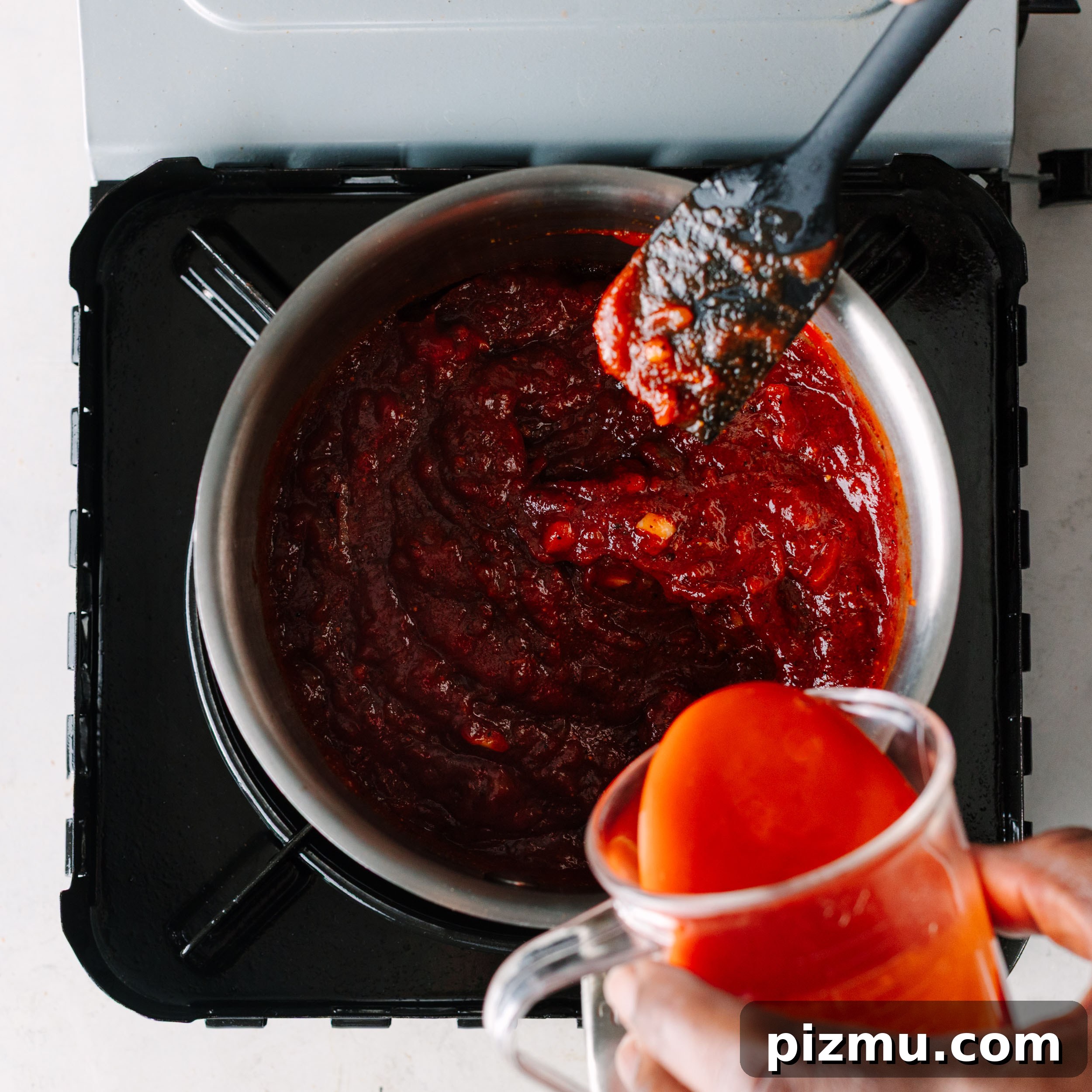 Buffaque Wings Recipe: Buffalo BBQ Chicken Wings 10 Tomato paste being added to a pan.